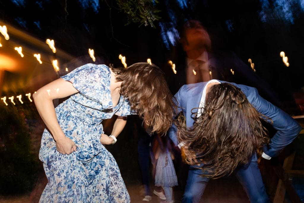 Wedding guests dancing under string lights at a Leonard Lake Reserve summer camp wedding