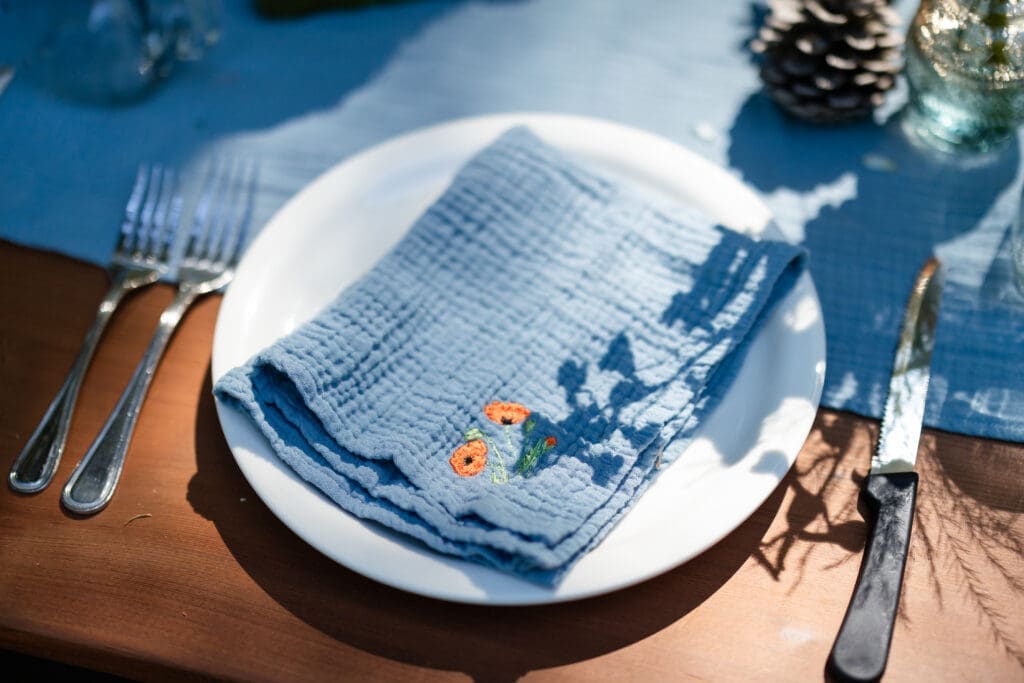 Hand embroidered napkins at a DIY Mendocino County wedding reception table