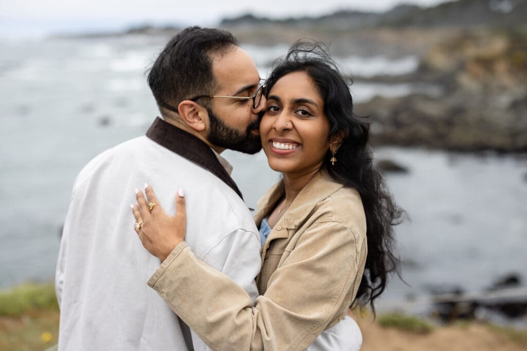 Couple embraces over bluffs at the Mendocino Botanical Gardens after surprise proposal